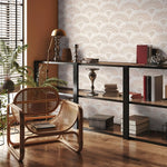 Modern interior with a wicker chair, bookshelf, and decorative items.