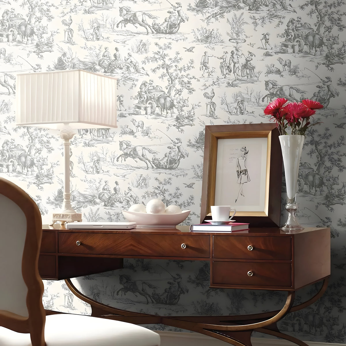 Wooden desk with decorative items against a patterned wallpaper wall.