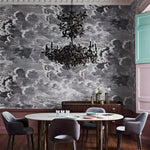 Dining room with a chandelier, table, and chairs against a patterned wall.
