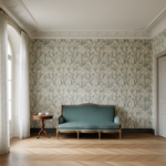 Vintage-style room with a teal sofa and wooden table against a patterned wall.
