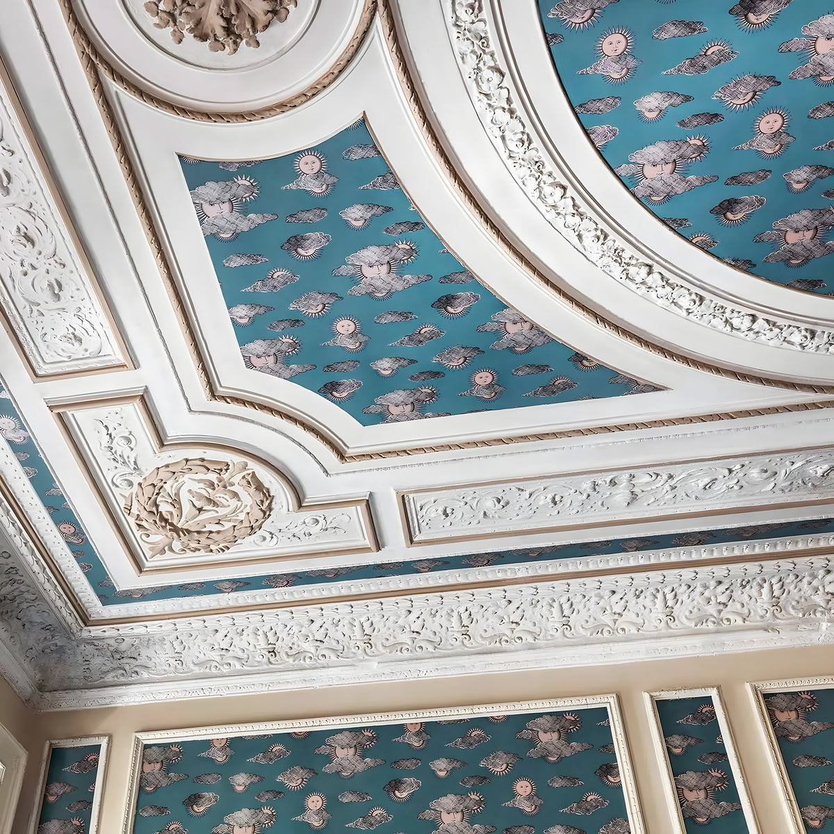 Decorative ceiling with intricate patterns and blue wallpaper