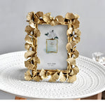Gold decorative photo frame on a white surface with a gray background