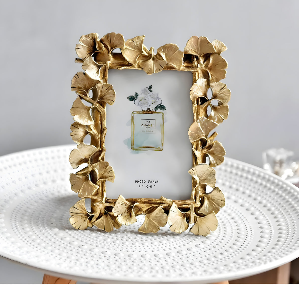 Gold decorative photo frame on a white surface with a gray background