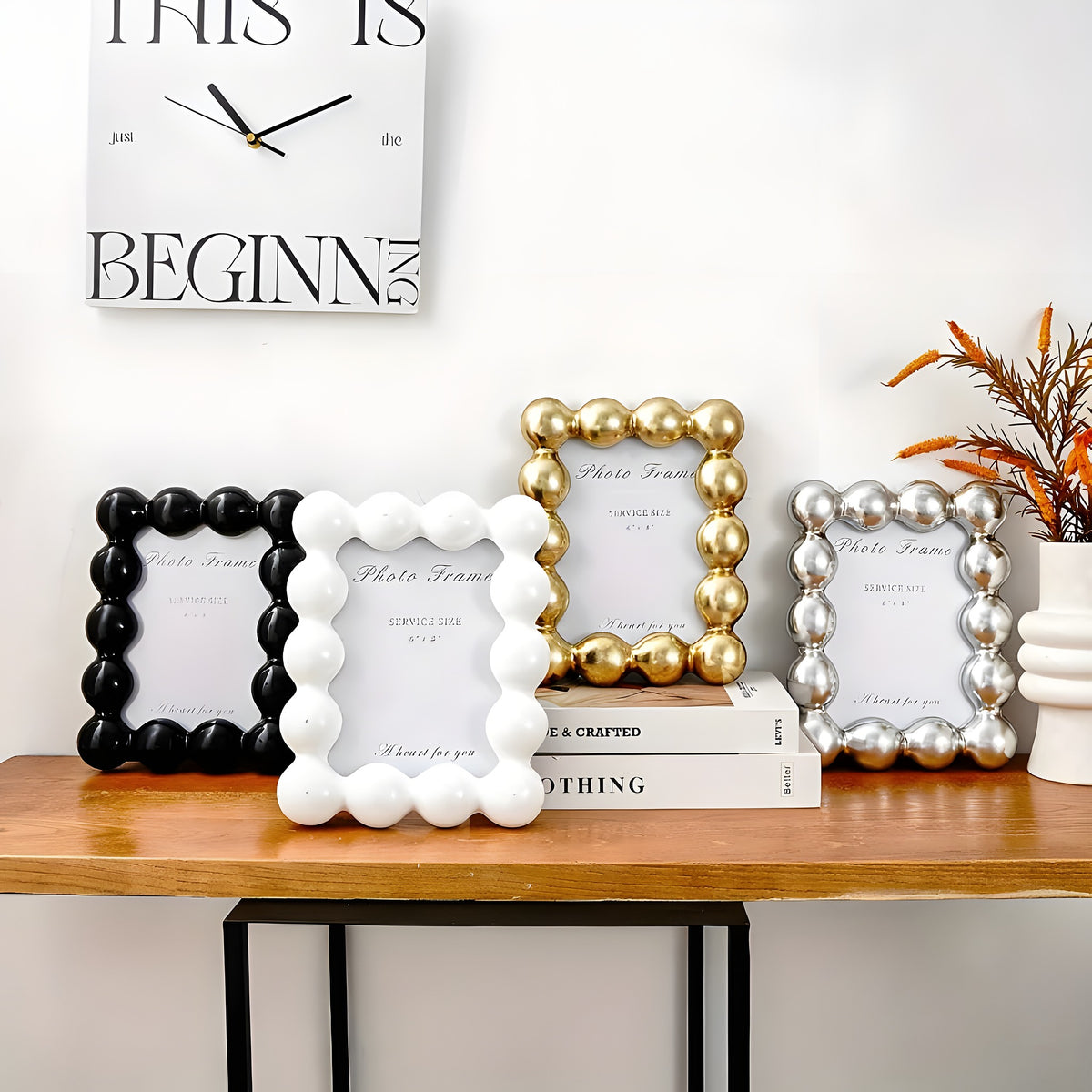 Decorative photo frames on a wooden surface with a clock above