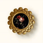 Decorative brooch with floral design and gold frame on a white background