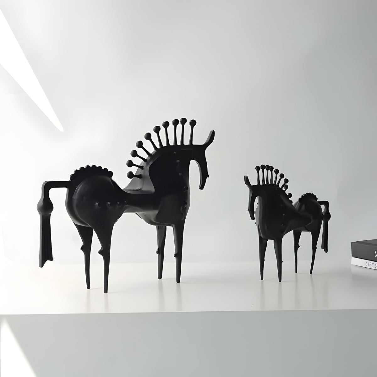 Black horse-shaped chairs on a white surface with a white background