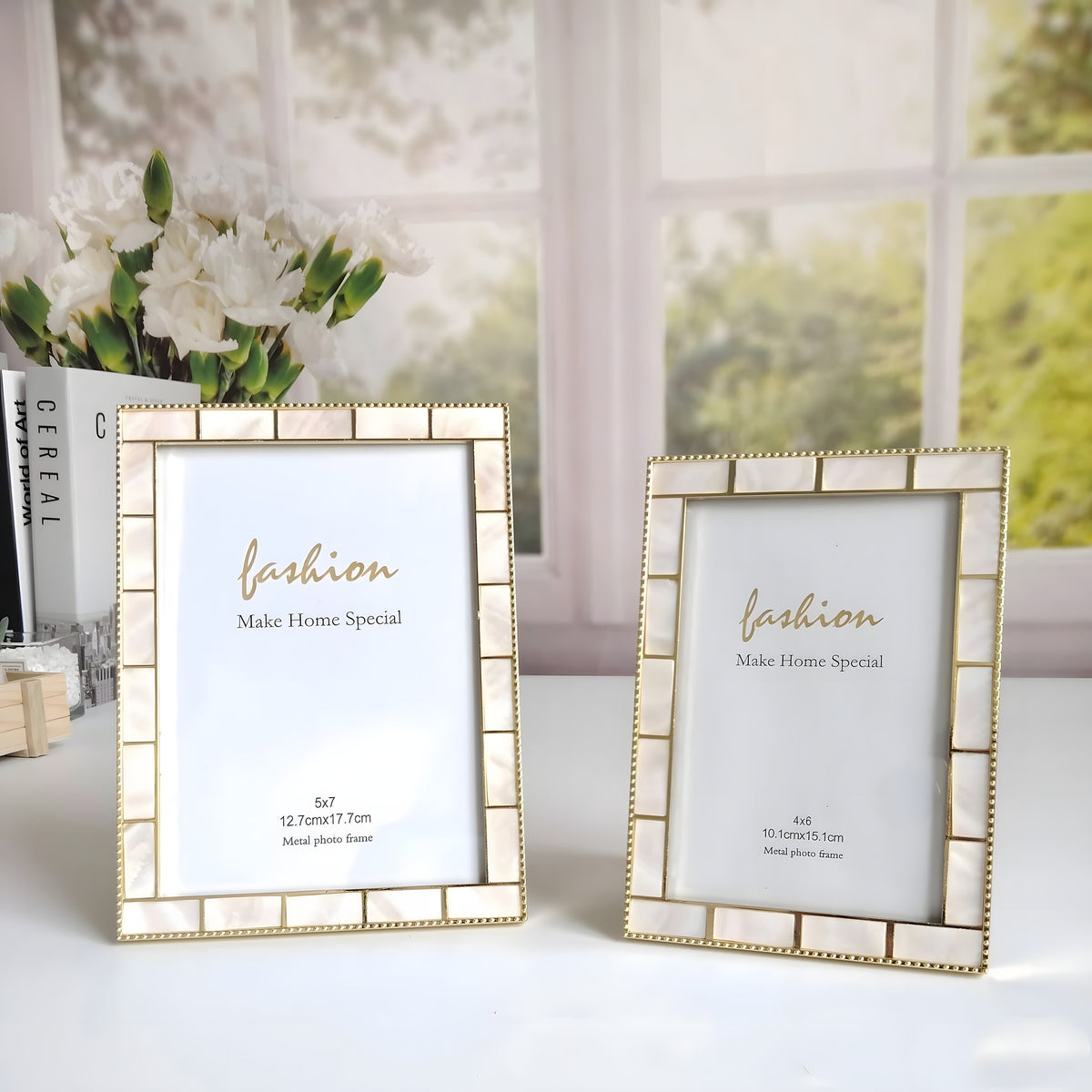 Two gold-framed picture displays on a surface with a blurred floral background