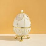 Decorative egg with gold accents and pearls on a beige background