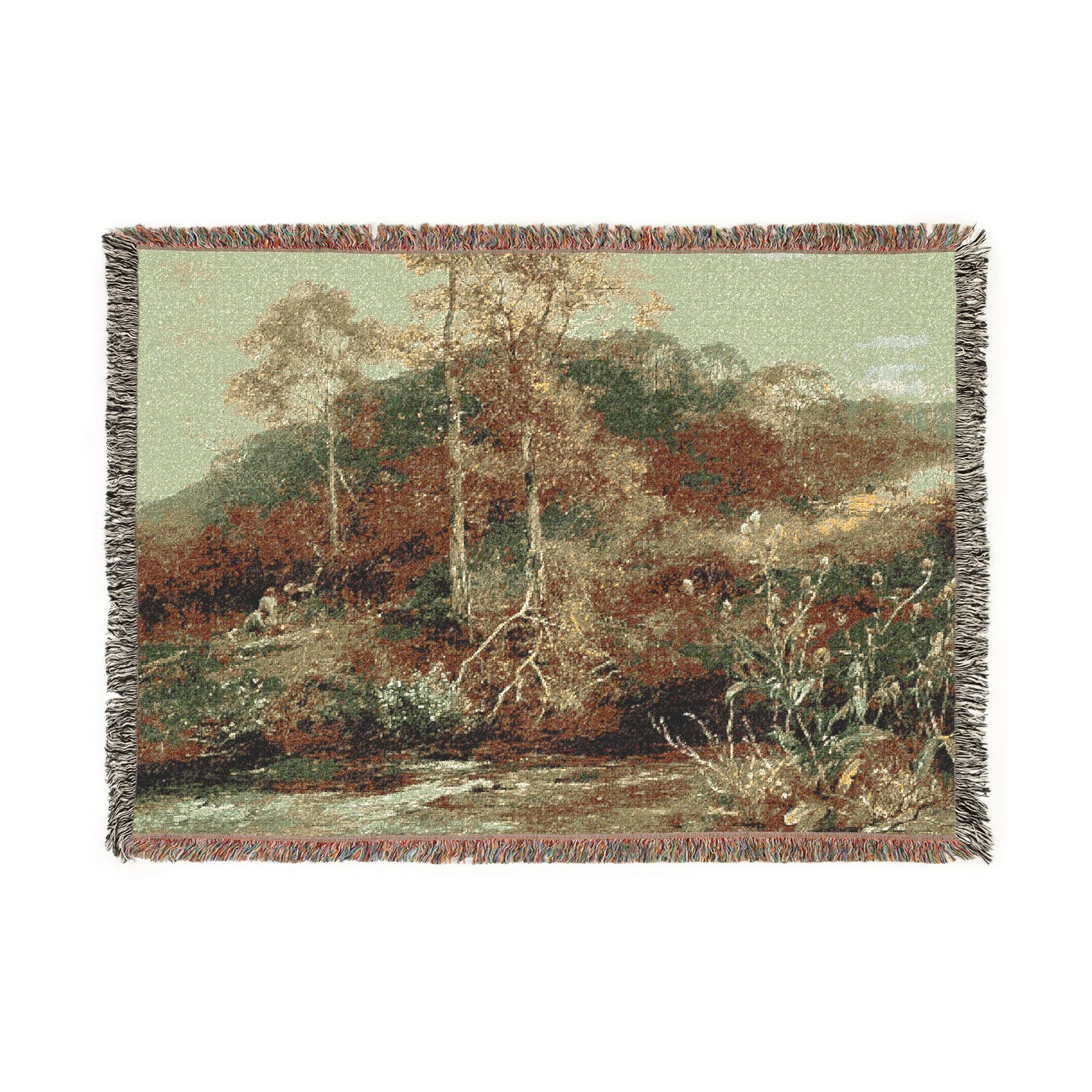 A rectangular woven tapestry with fringed edges, featuring a scenic landscape print of trees, hills, and a stream in muted earthy tones.