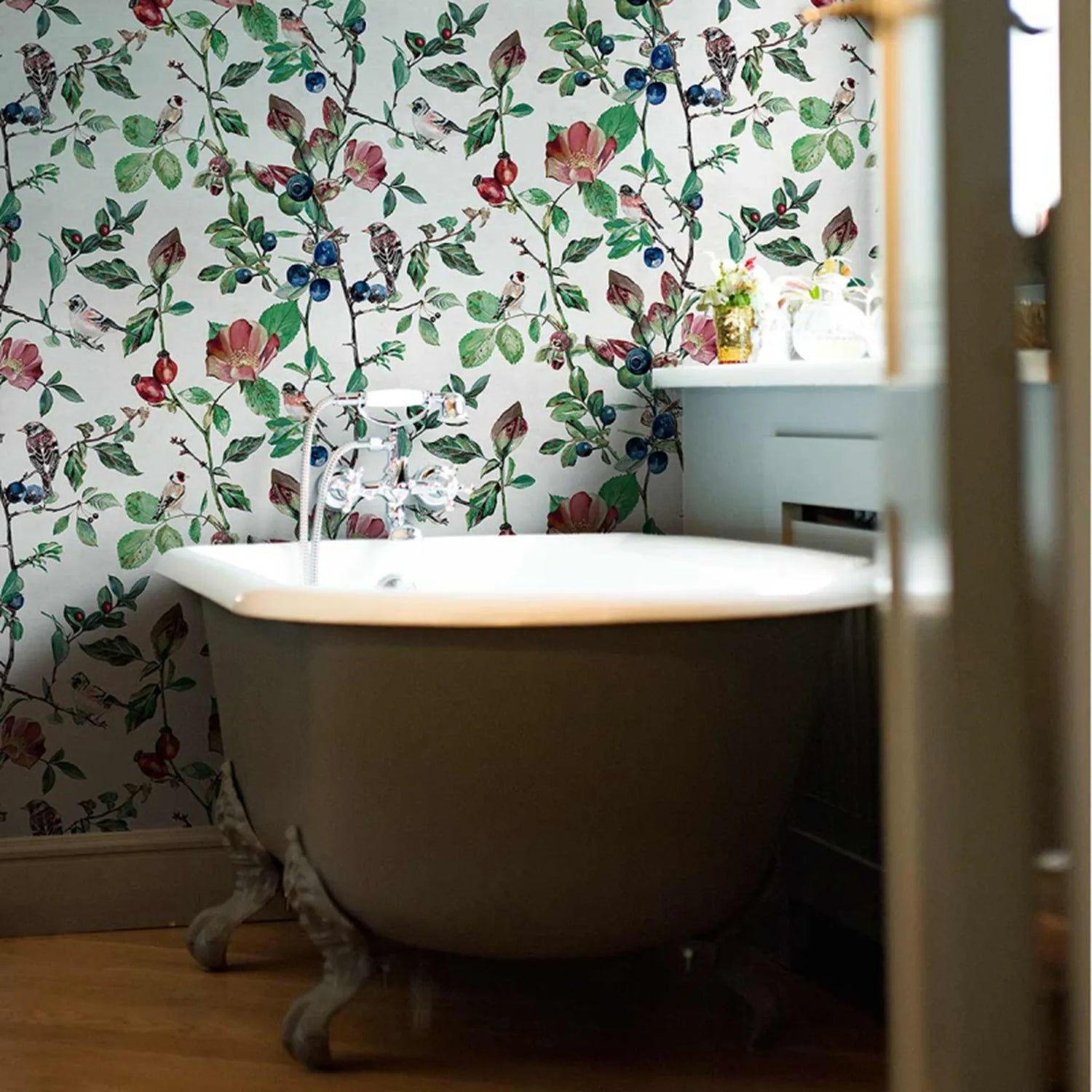 Bathroom with a freestanding bathtub and floral wallpaper.