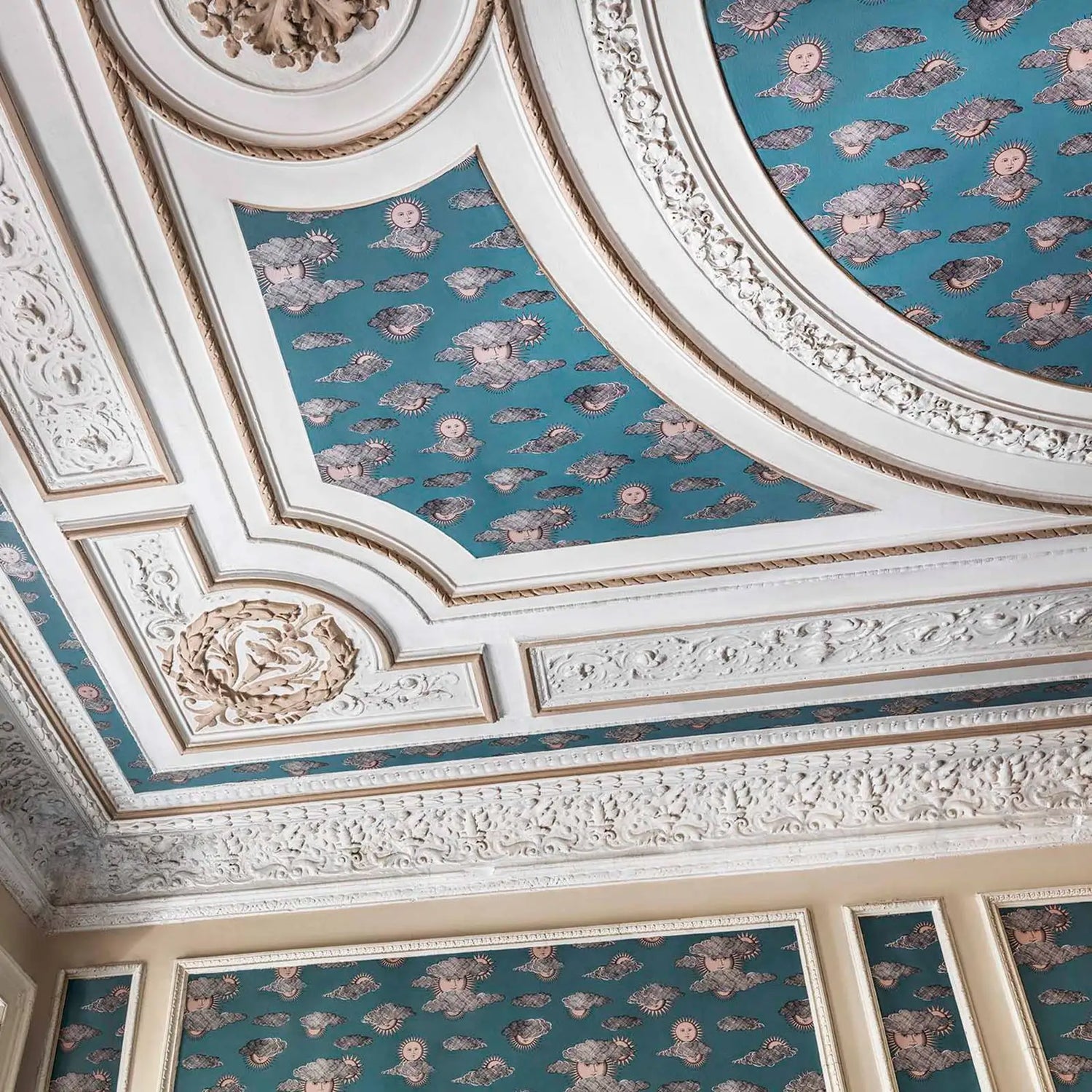 Decorative ceiling with intricate patterns and blue wallpaper