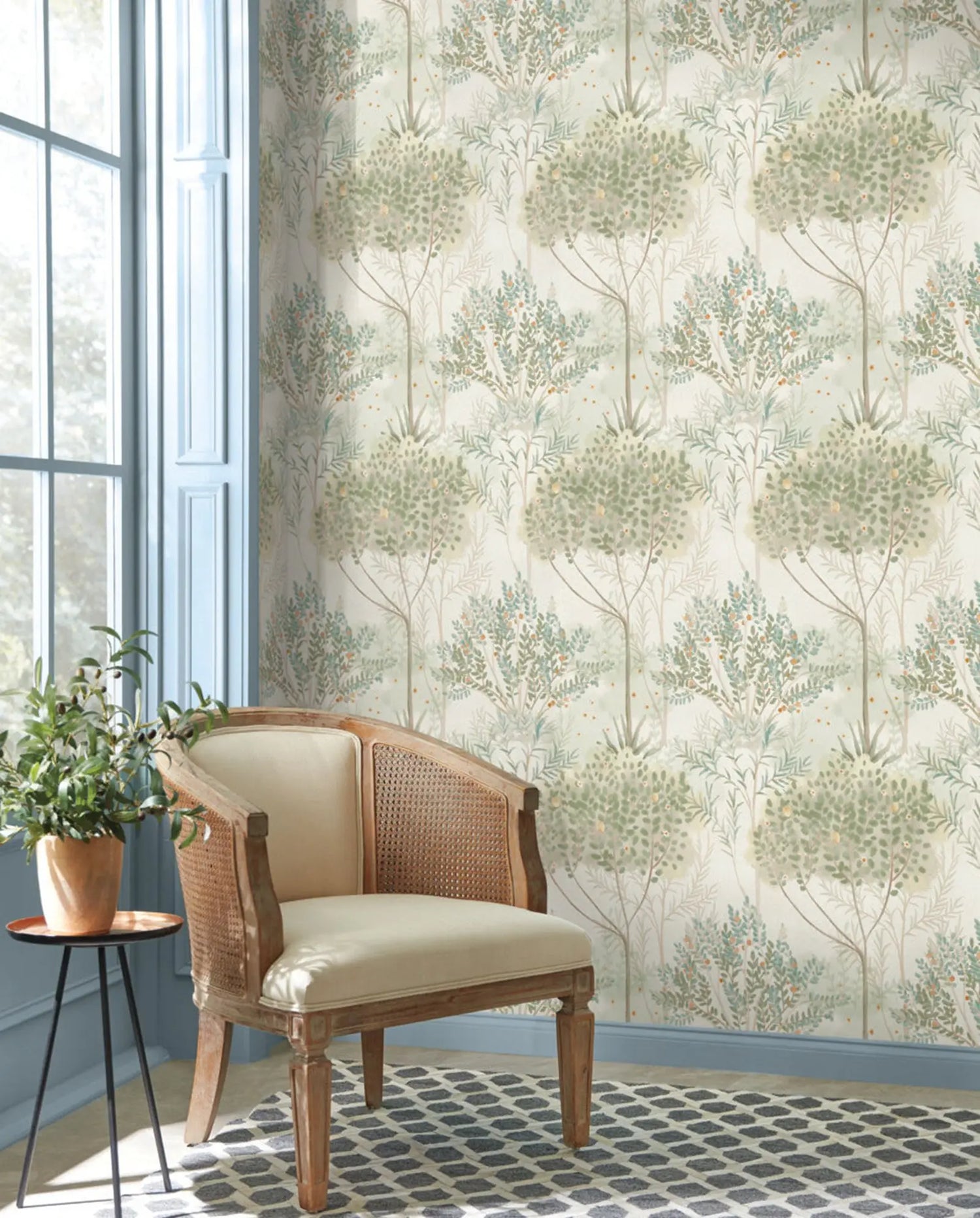 Wooden armchair with beige cushion against a wall with floral wallpaper
