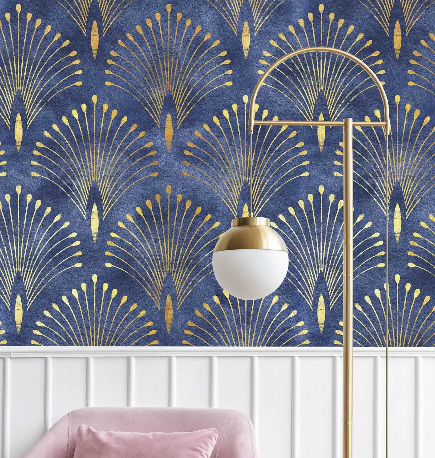 Gold geometric pattern on blue wallpaper with a gold lamp and pink chair.