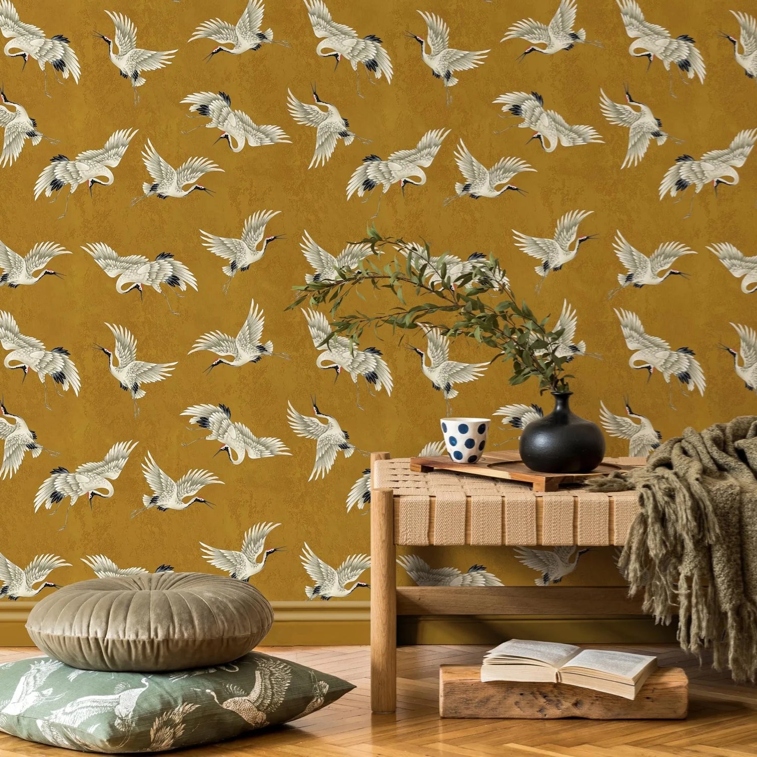 Room interior with a mustard yellow wall featuring bird pattern, wooden table, and decorative items.