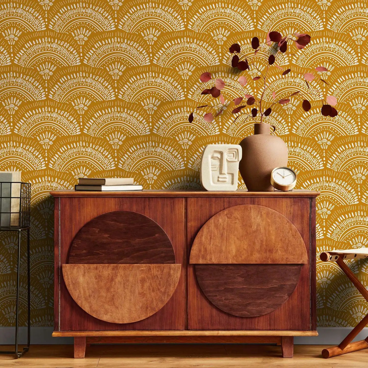 Wooden cabinet with decorative items against a patterned yellow wall