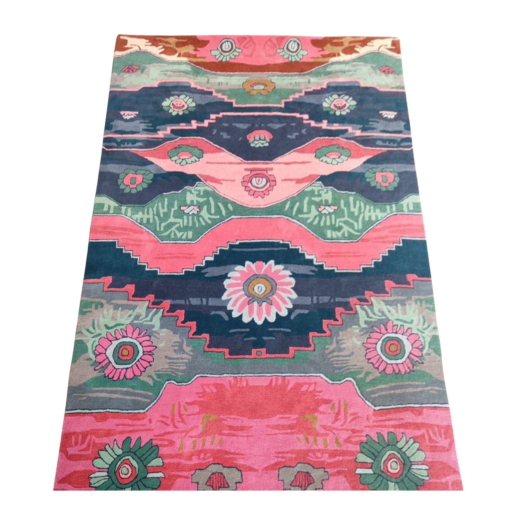 Colorful hand-tufted rug featuring Aztec geometric designs and floral medallions in shades of pink, teal, green, and dark blue.