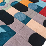 Colorful geometric-patterned rug with various shapes and colors.