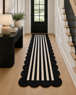 Black and white striped runner rug on a wooden floor with a side table and lamp in the background.