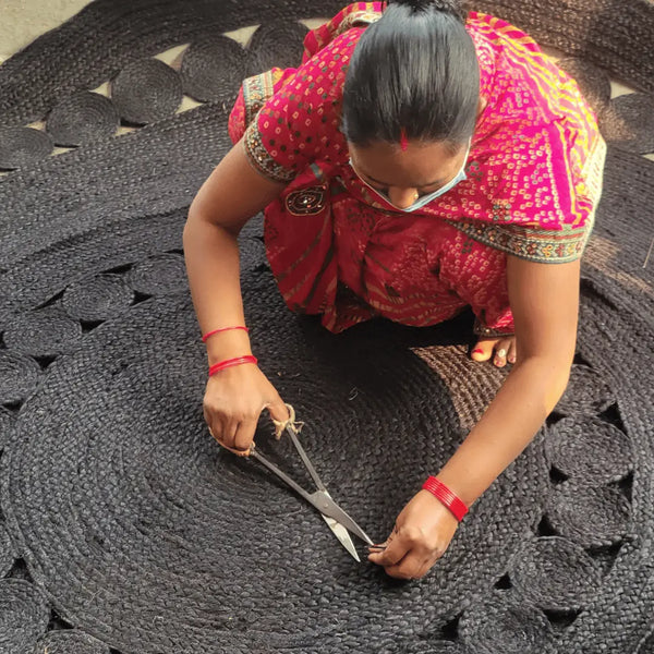 craftsman trimming fibers off jute rugs before sending to inspection