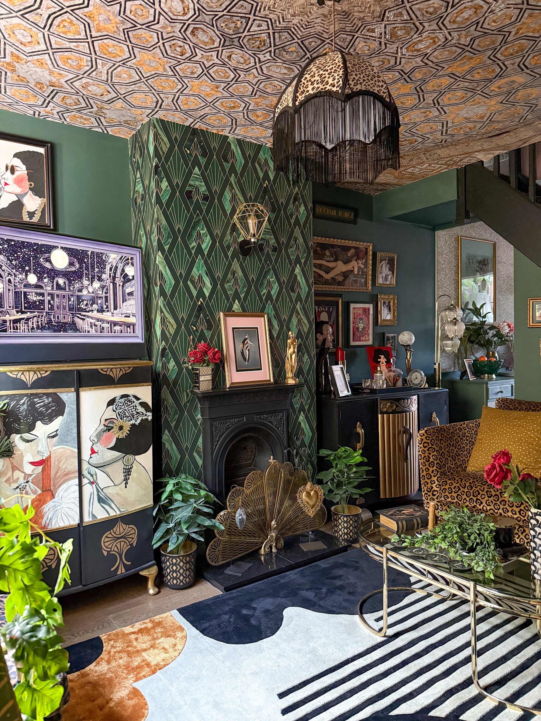 Decorative living room with patterned  art deco rug, wallpaper, fireplace, and various decor items.