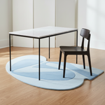 Modern dining table and chair on a light blue rug with a minimalistic background