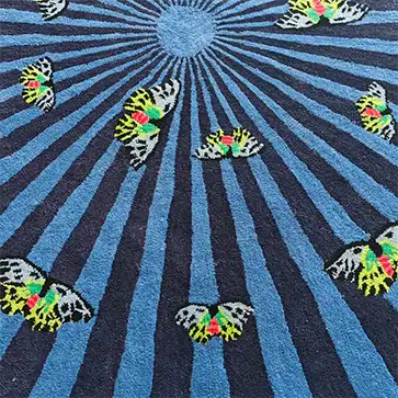 A vibrant blue hand-tufted wool area rug featuring a striking pattern of colorful butterflies over a radial design. Ideal for adding a pop of color to bedrooms or as a large area rug in living rooms. This round wool rug combines artistic flair with cozy comfort, making it a standout piece among rugs for bedroom and large area rugs collections.