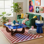 Modern living room with a green sofa, colorful coffee table, Candy Everyday Hand Tufted Wool Rug, and abstract art on the wall.