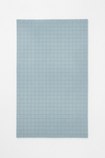 Rectangular blue rug with a grid pattern on a white background