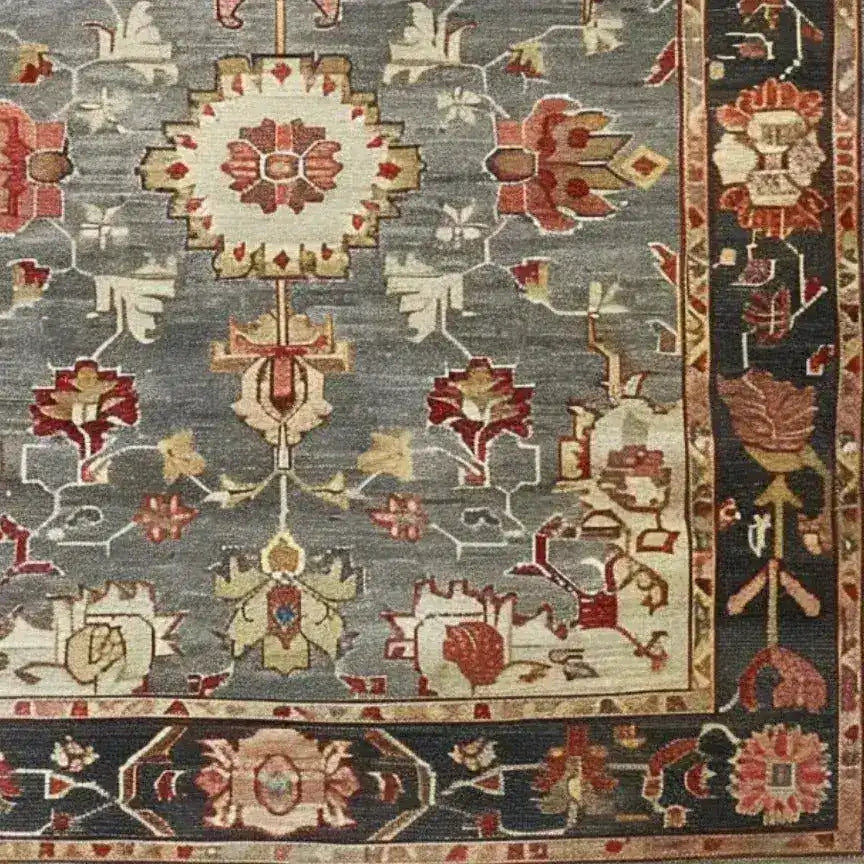 A detailed view of the Charming Floral Cascade Hand Knotted Area Rug, showcasing intricate floral patterns in warm tones on a soft, muted background. The border features complementary designs, highlighting the craftsmanship of this elegant area rug.
