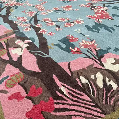 A beautifully detailed area rug featuring a serene cherry blossom design in a hand-tufted wool texture. Perfect for enhancing a living room, this large rug combines elegant floral patterns in pink and blue hues, ideal for those seeking area rugs for a living room with a touch of artistic flair.