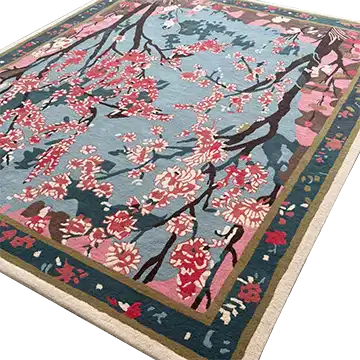 Beautiful Cherry Grove Serenity hand-tufted area rug perfect for a living room, featuring an intricate floral design with pink and red cherry blossoms against a soft blue background. This wool rug adds elegance and color, making it an ideal choice for large living room rugs.