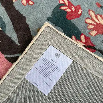 Close-up view of the Cherry Grove Serenity Hand Tufted Rug, showcasing its detailed floral pattern and durable backing, ideal for adding elegance to your living room. This wool area rug is perfect for those seeking large living room rugs.