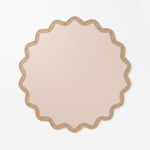 Round beige rug with scalloped edge on a light gray background