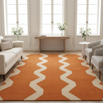 Living room with a large orange and beige zigzag patterned rug, white sofa, and chairs.