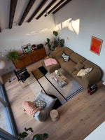 Modern living room with brown rug,  sectional sofa, coffee table, and decorative items.