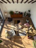 Living room with a rug, wooden floor, furniture, and decorative elements.