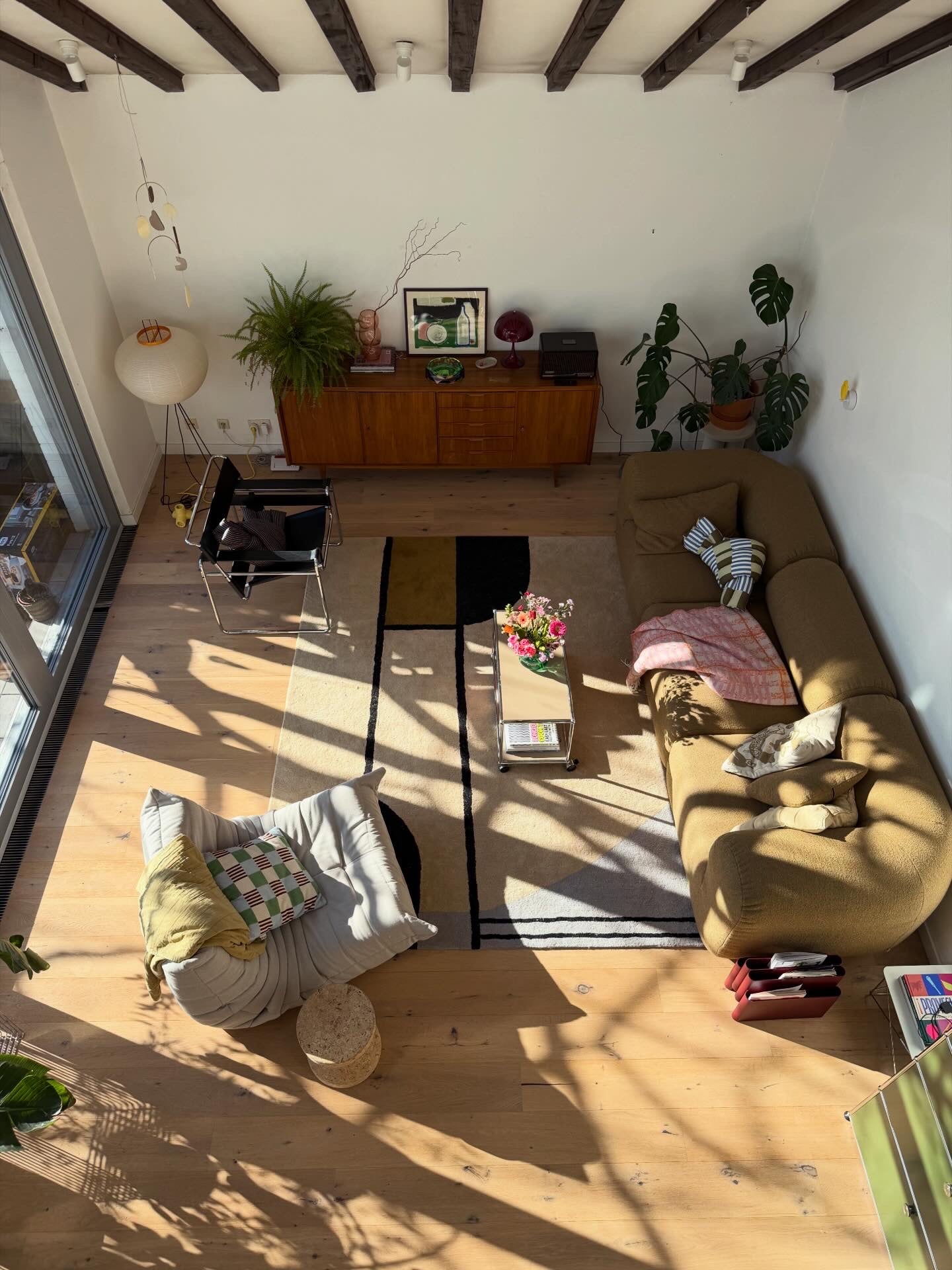Living room with a rug, wooden floor, furniture, and decorative elements.
