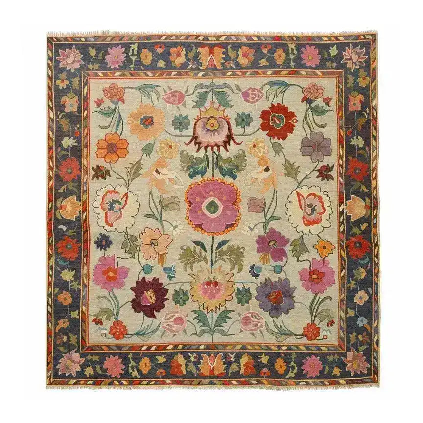 Vibrant and colorful hand-knotted area rug featuring a rich floral pattern with a variety of flowers in bold hues. The intricate design is bordered by a dark frame, enhancing the beauty of this elegant rug.
