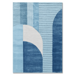 A square area rug featuring an abstract geometric pattern in shades of blue and white, with vertical textured stripes and curved arch shapes.