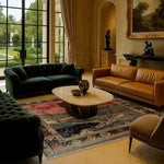 A beautifully decorated living room featuring the Countryside Charm Hand Knotted Area Rug. This vintage wool rug, with its intricate patterns and rich colors, adds a touch of elegance to the space. The square area rug is perfectly placed under a modern coffee table, surrounded by plush sofas, making it an ideal choice for both office and living room settings.
