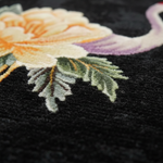 Close-up of embroidered floral design on black rug