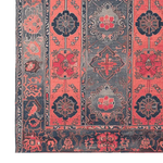 This image showcases the Crimson Dreams Hand Tufted Area Rug, featuring a vintage design with intricate floral patterns in rich red and navy hues. Perfect for large living rooms, this wool rug offers a timeless elegance and a cozy touch.