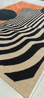 Rug with black and beige wavy pattern on a wooden floor