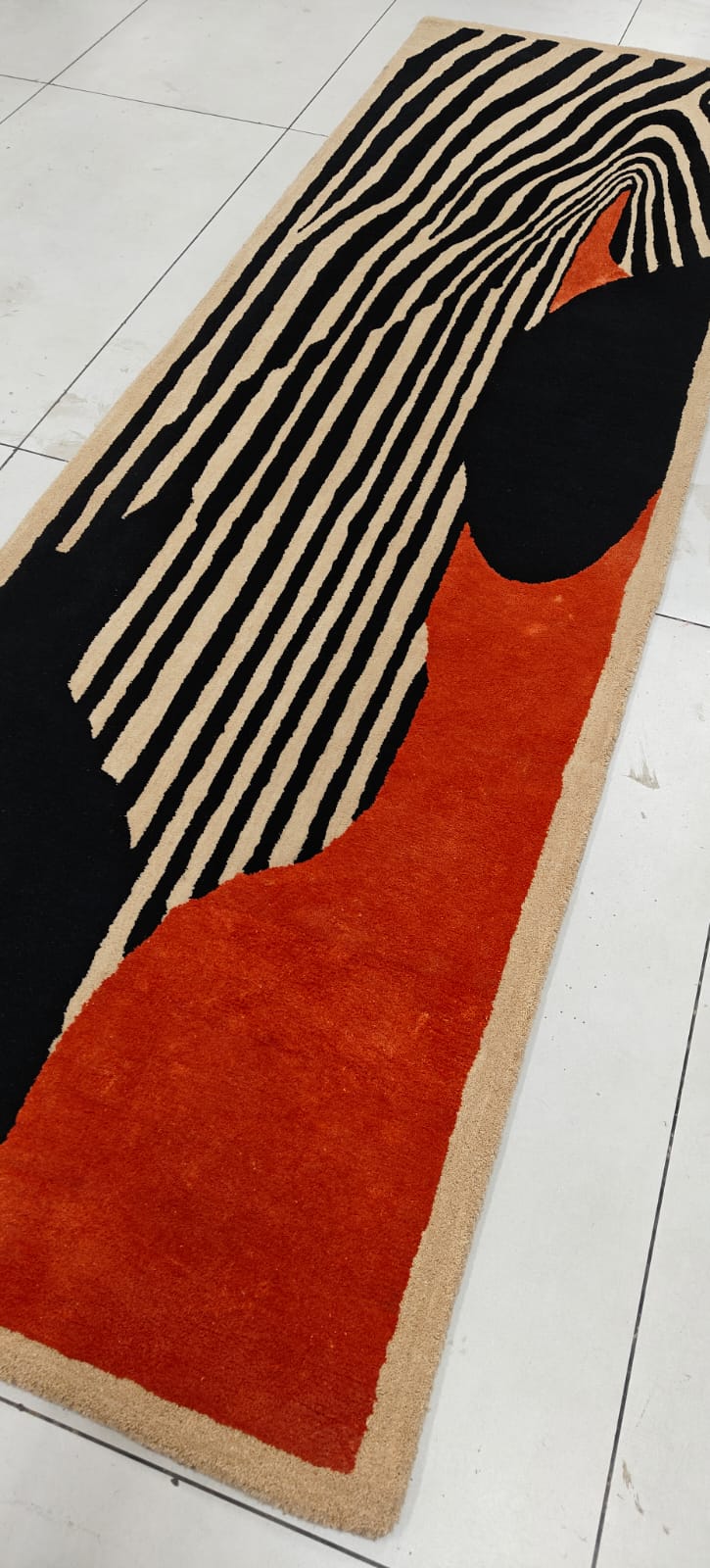 Long rectangular rug with zebra pattern on a tiled floor