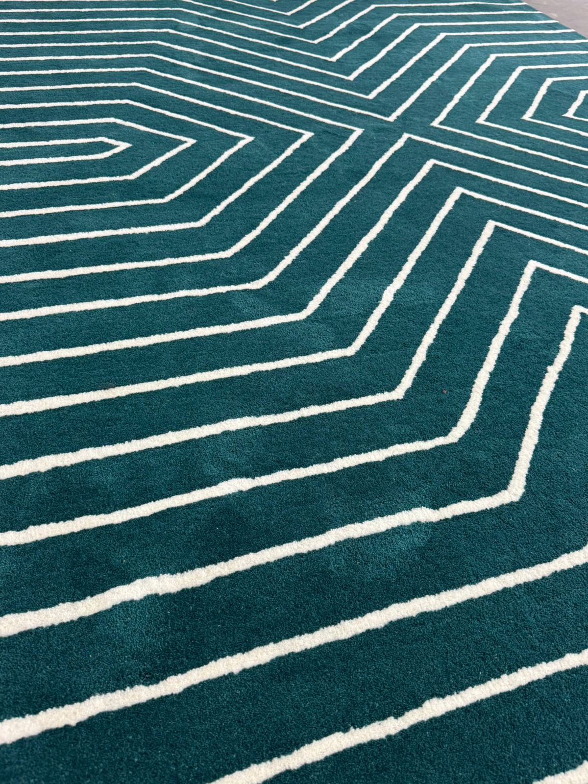 Teal rug with white geometric pattern
