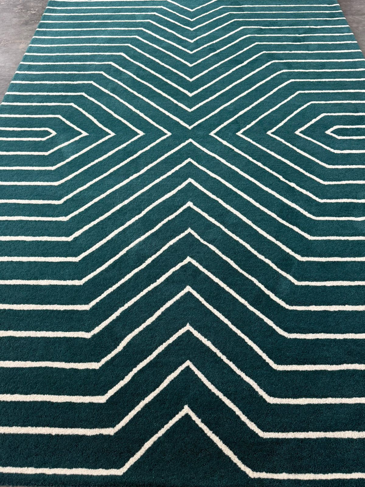 Teal rug with white geometric pattern