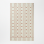 Patterned rug with pink polka dots and stripes on a light background