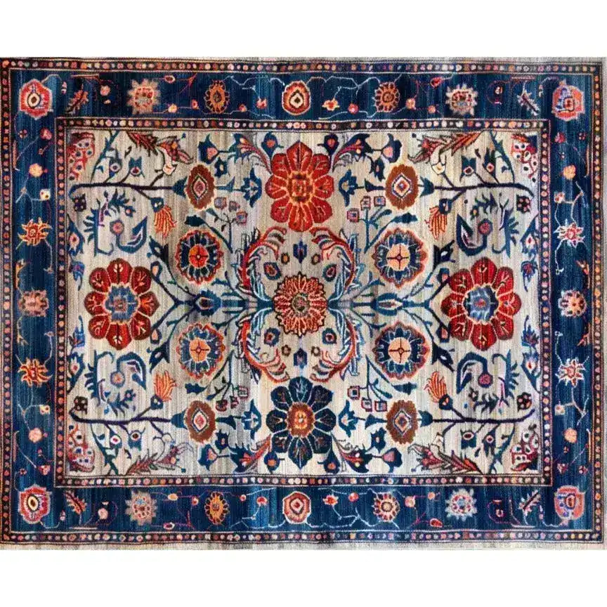 A beautifully intricate Dreamy Floral Escape hand-knotted wool rug featuring a vintage Persian design. The area rug displays an array of vibrant floral patterns in shades of red, blue, and orange, making it an ideal choice for dining room carpets or a living room centerpiece. This floral rug captures the essence of traditional Persian rugs, perfect for adding a touch of elegance to any space.