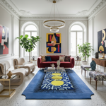 Modern living room with a red sofa, blue rug, and abstract art on white walls.
