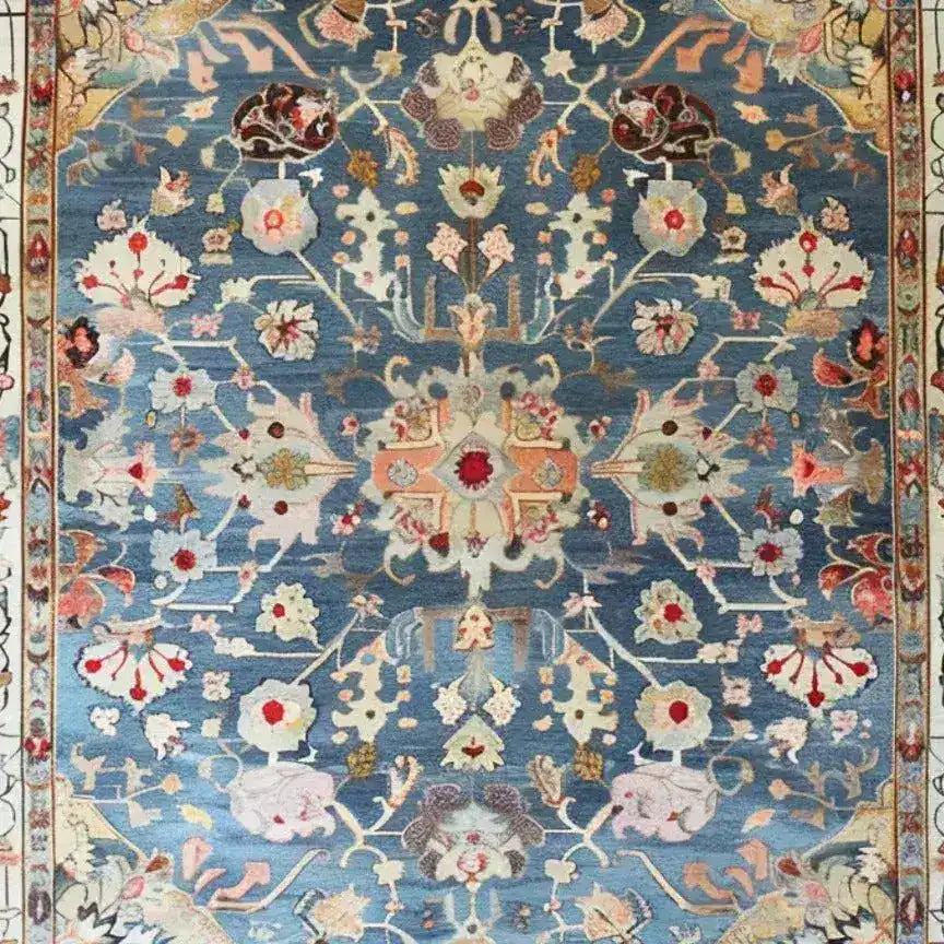 Elegant blue floral hand-knotted area rug featuring intricate patterns and vibrant colors, showcasing a detailed central medallion surrounded by ornate floral motifs on a blue background.